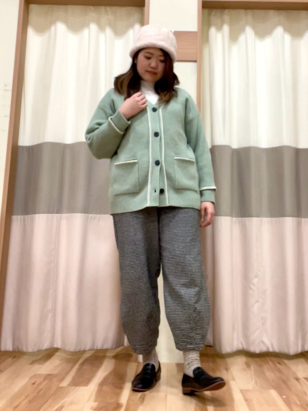 グレー系のその他パンツ、グリーン系のカーディガン/ボレロ、ホワイト系のシャツ/ブラウスを着用したレディースの冬コーディネートの1枚目の写真