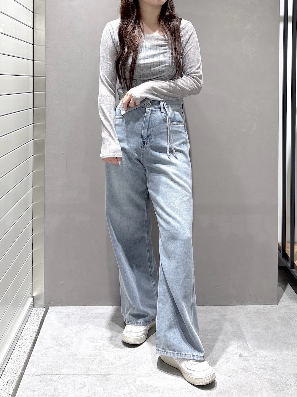 グレー系のTシャツ/カットソー、ブルー系のデニムパンツを着用したレディースの春コーディネートの1枚目の写真
