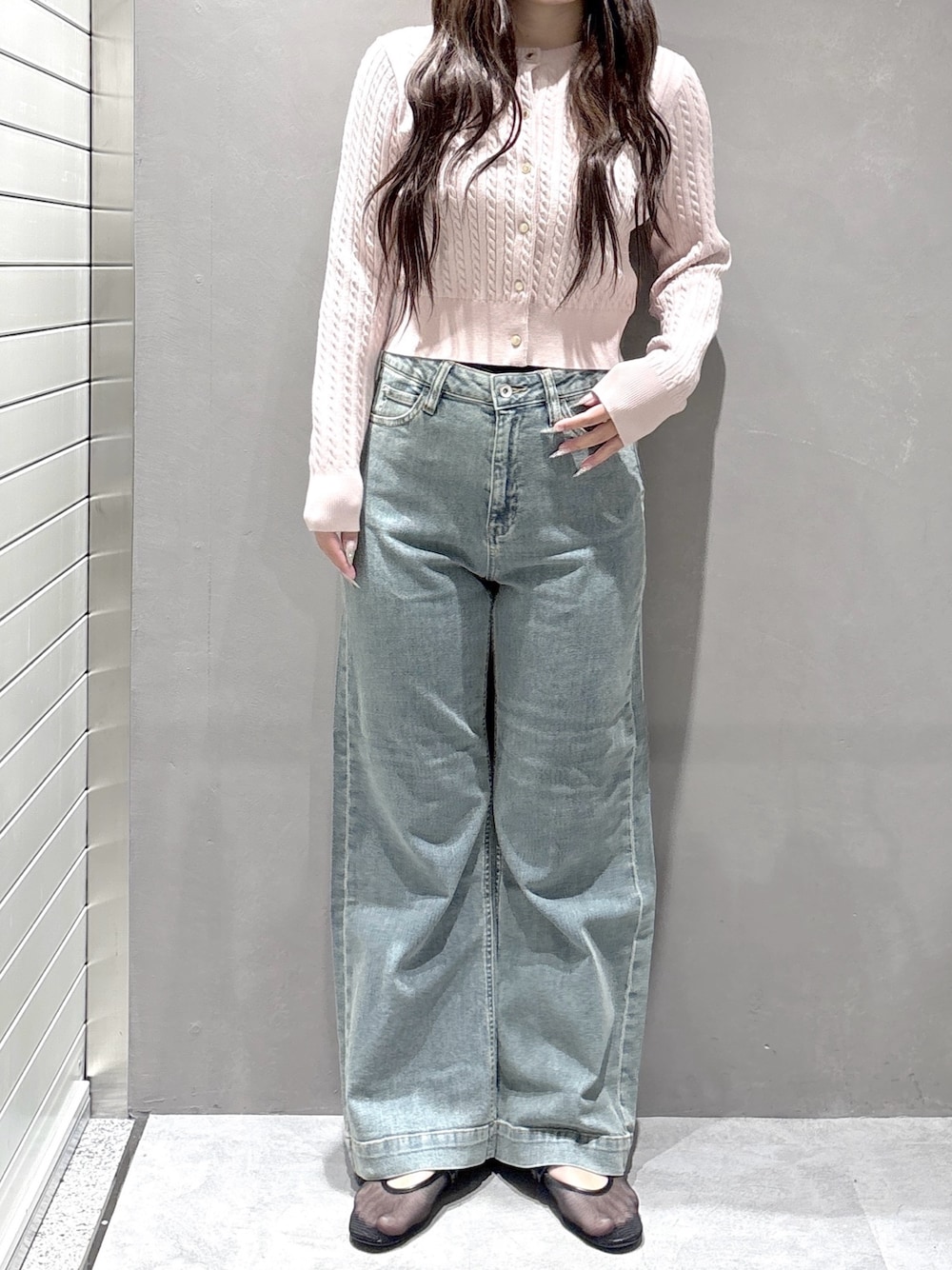 ピンク系のニット/セーター、ブルー系のデニムパンツを着用したレディースの春コーディネートの1枚目の写真