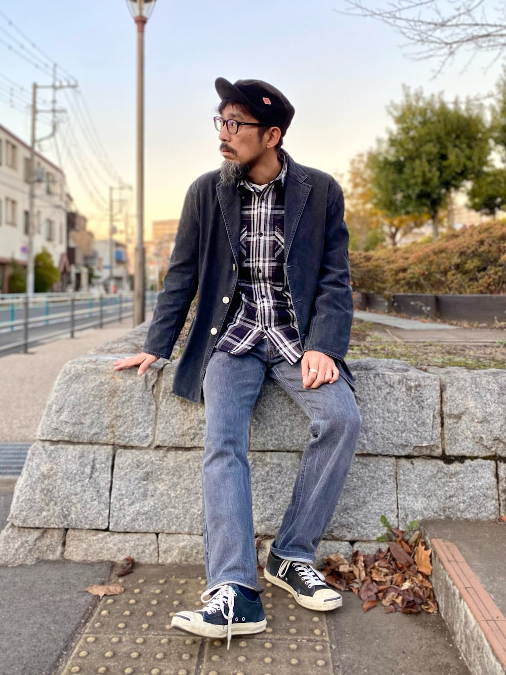 グレー系のデニムパンツ、ブラック系のスニーカー、ブラック系のテーラードジャケットを着用したメンズの冬コーディネートの1枚目の写真