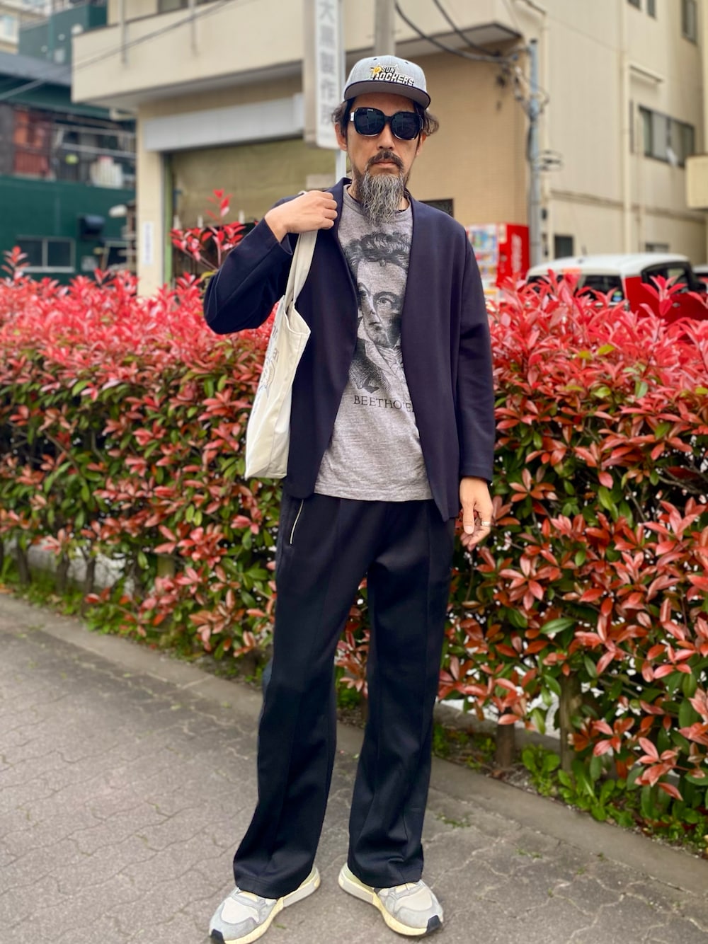 「ジャージ、トラックパンツ、キャップ、サングラス、プリントT、モノトーン、スニーカー、トートバッグ、休日スタイル、春コーデ、UNIQLO、カーディガン、スポーツミックス、お出かけコーデ、ストリート」｜「UNIQLOのアイテム（カーディガン/ボレロ、ブラック系）」を使った、ヤギハシカズヒロさん（メンズ・181cm）の春コーディネートの1枚目の写真