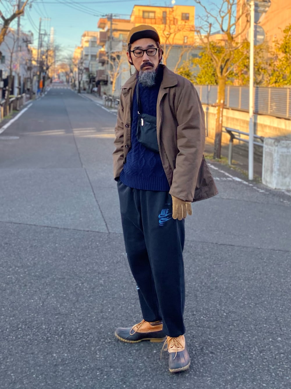 ブラウン系のその他アウター、ブルー系のニット/セーター、ブラック系のショルダーバッグを着用したメンズの冬コーディネートの1枚目の写真