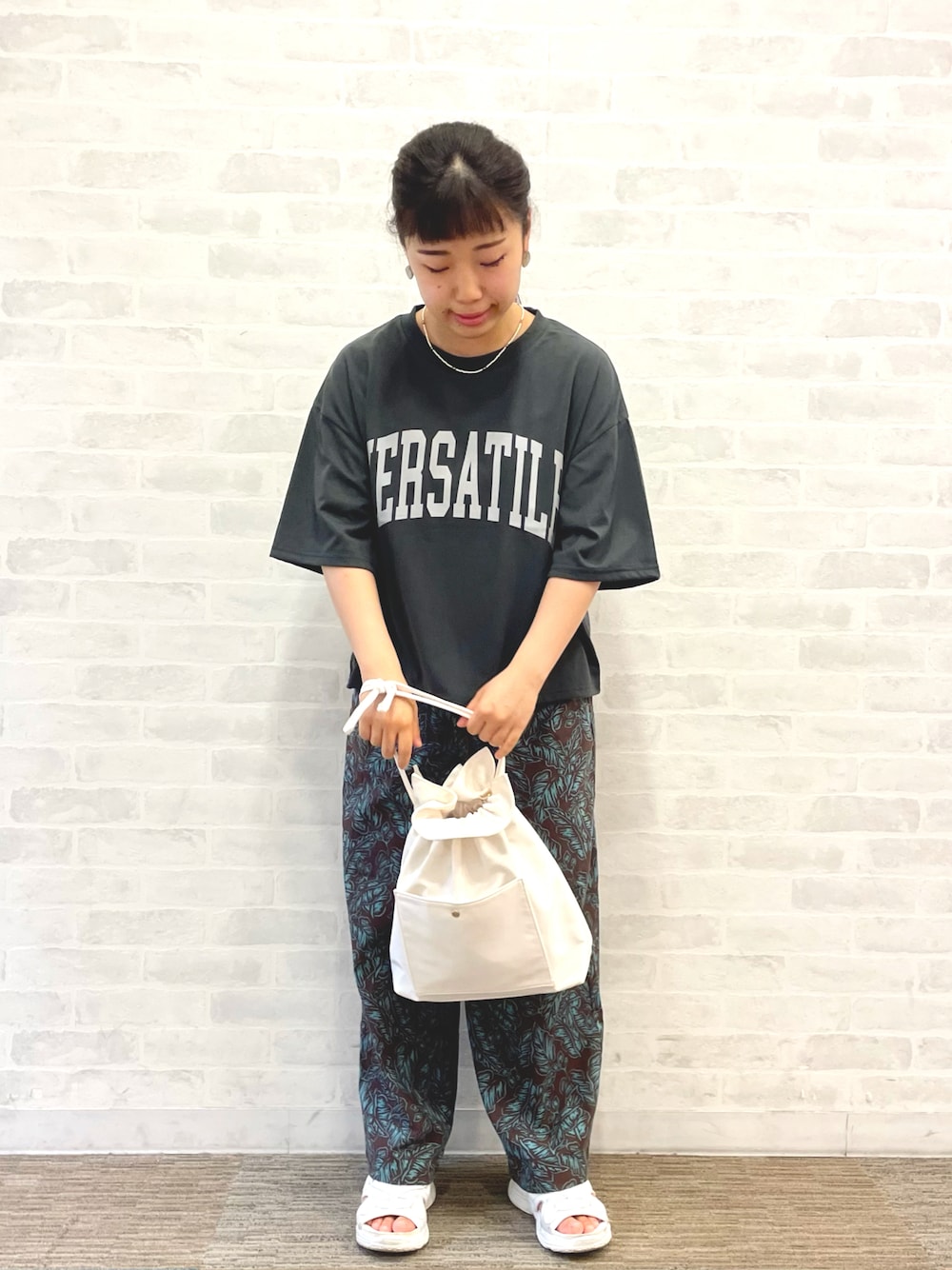 グレー系のTシャツ/カットソー、ホワイト系のハンドバッグ、ブラウン系のその他パンツを着用したレディースの夏コーディネートの1枚目の写真