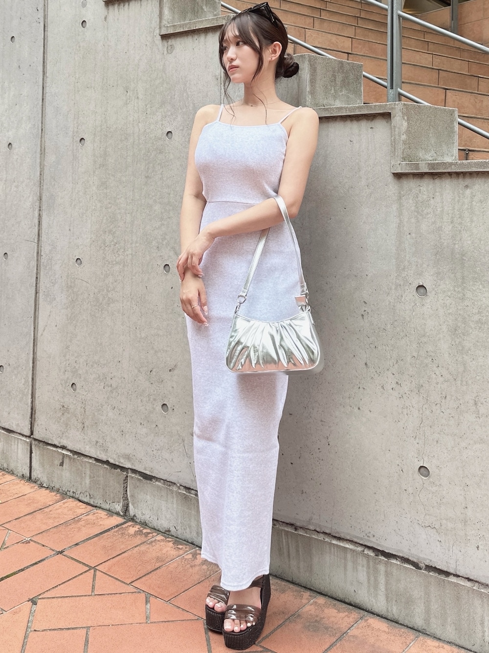 グレー系のワンピース、シルバー系のハンドバッグ、ブラック系のサンダルを着用したレディースの夏コーディネートの1枚目の写真