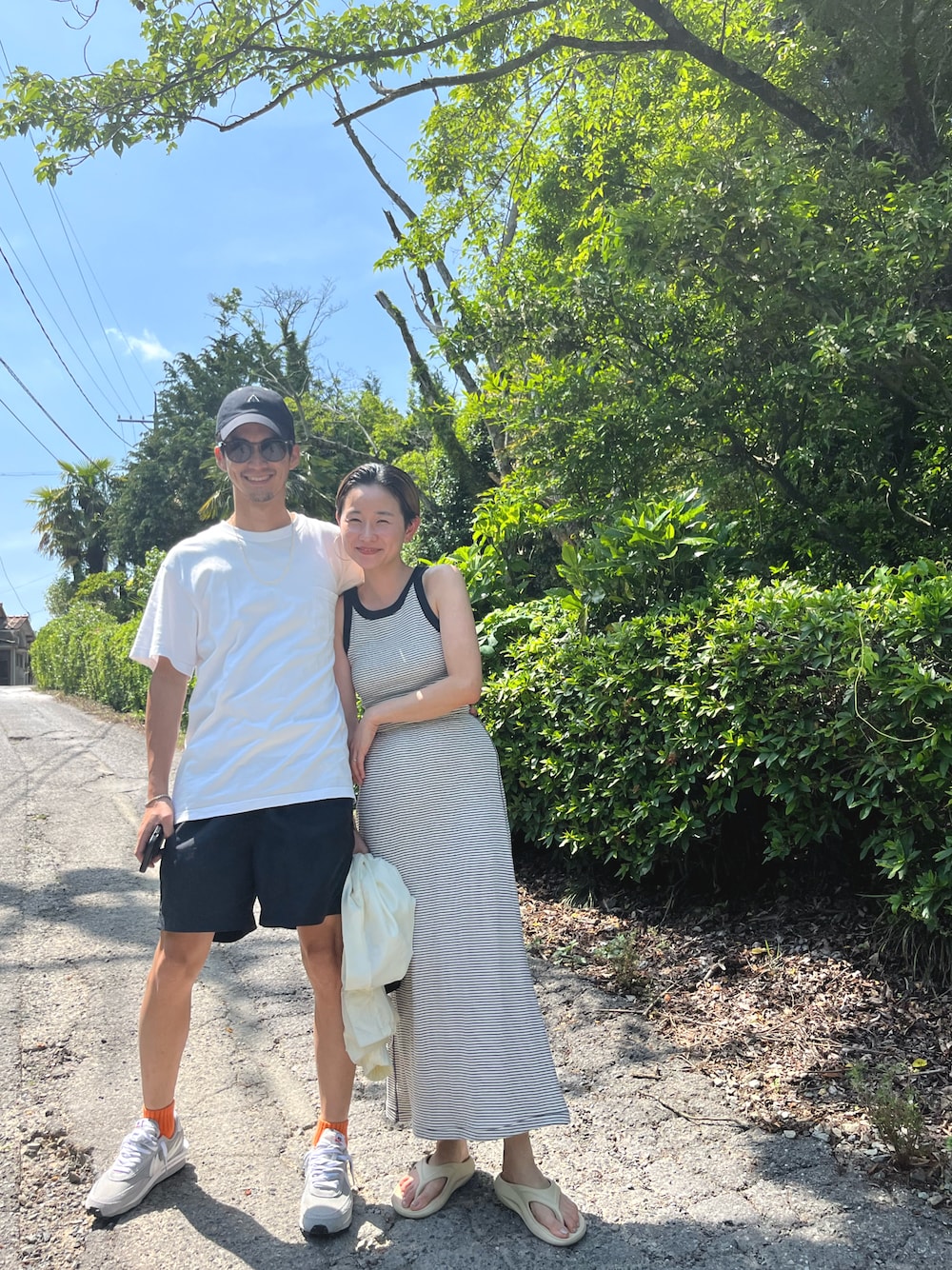 ブルー系のスカート、ブルー系のタンクトップ、ホワイト系のブルゾンを着用したレディースの春コーディネートの1枚目の写真