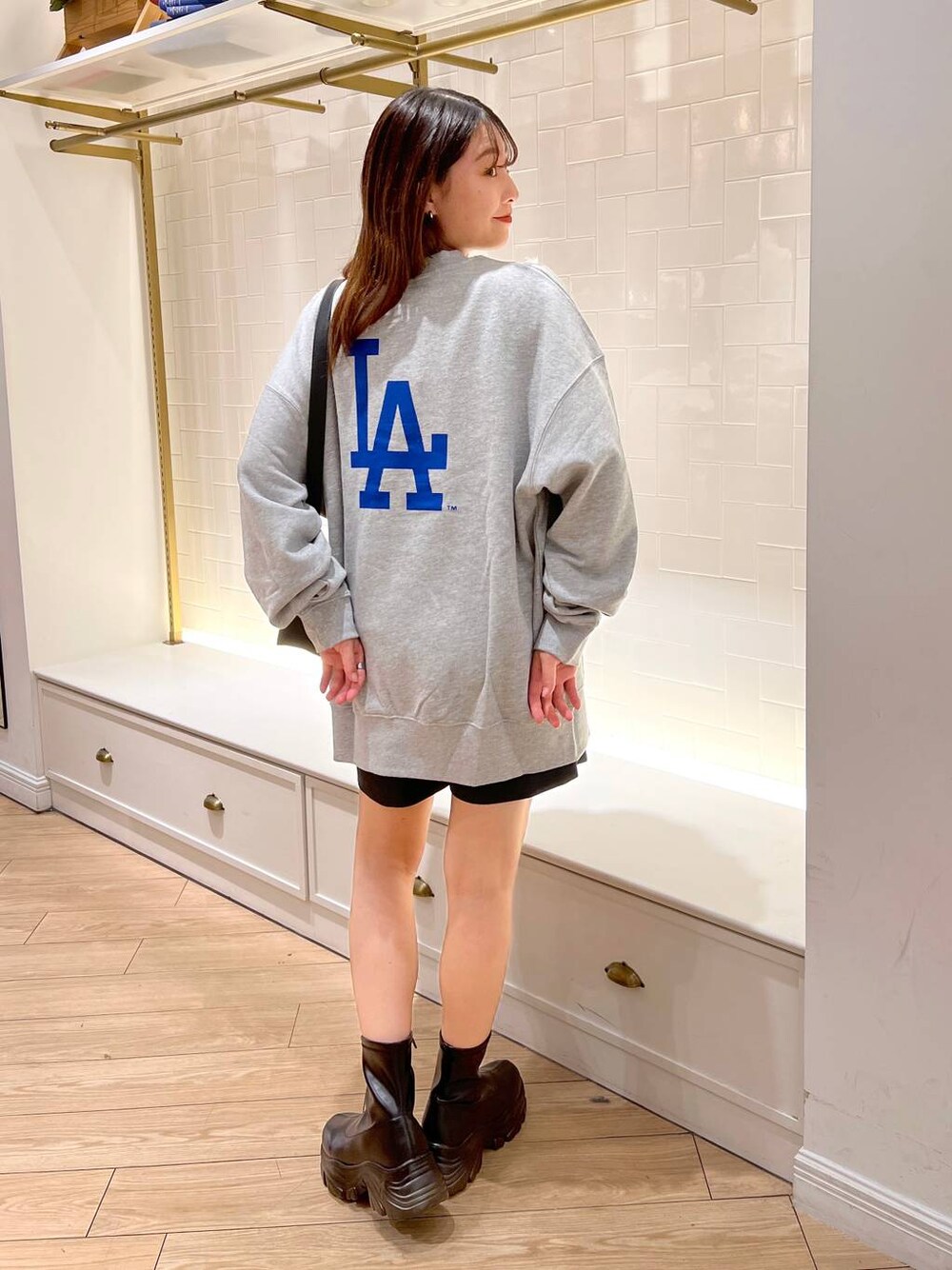 ブラック系のブーツ、グレー系のその他パンツ、ブラウン系のショルダーバッグを着用したレディースの秋コーディネートの1枚目の写真