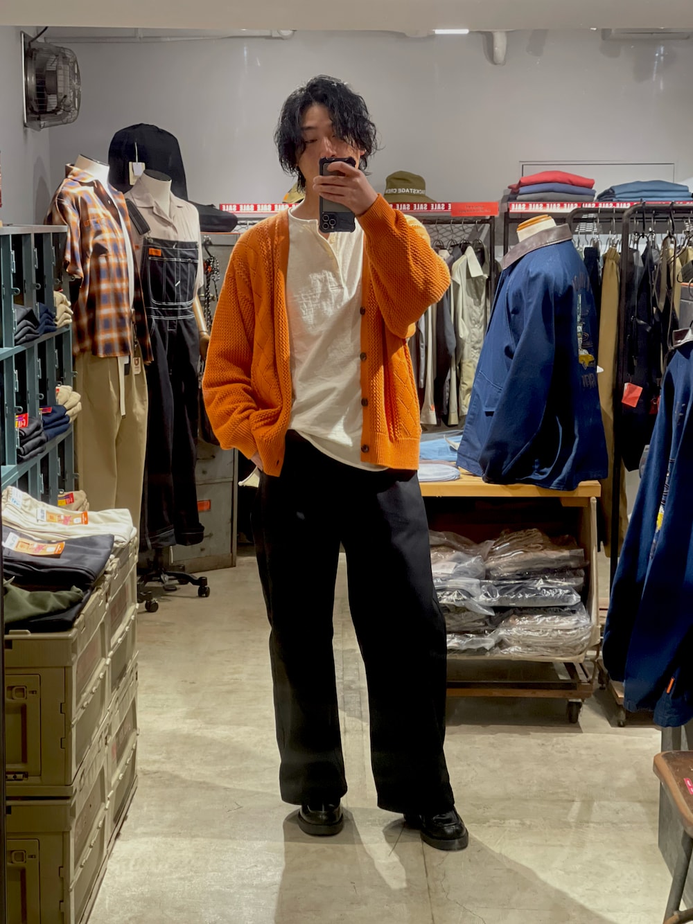 ブラック系のチノパンツ、オレンジ系のカーディガン/ボレロ、ベージュ系のTシャツ/カットソーを着用したメンズの春コーディネートの1枚目の写真