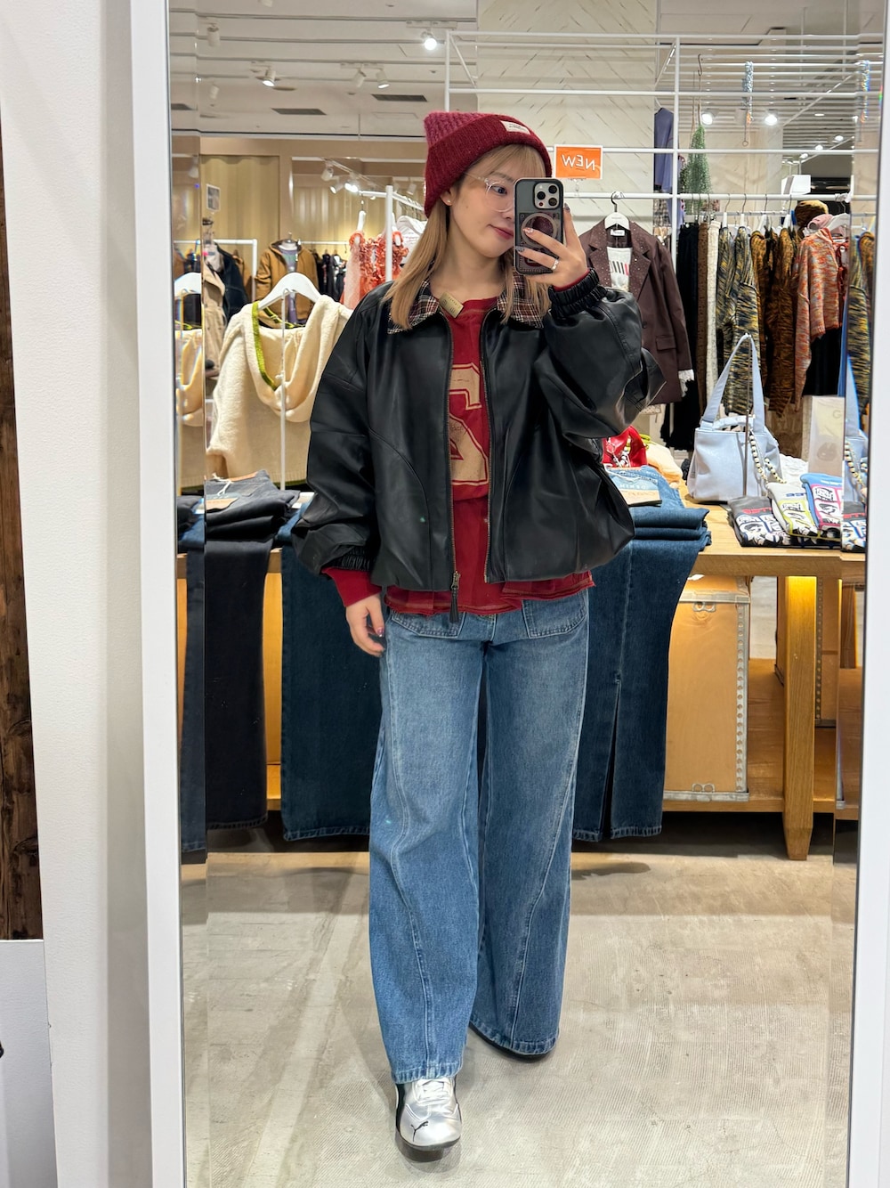 ブラック系のブルゾン、レッド系のTシャツ/カットソー、ブルー系のデニムパンツを着用したレディースの秋コーディネートの1枚目の写真