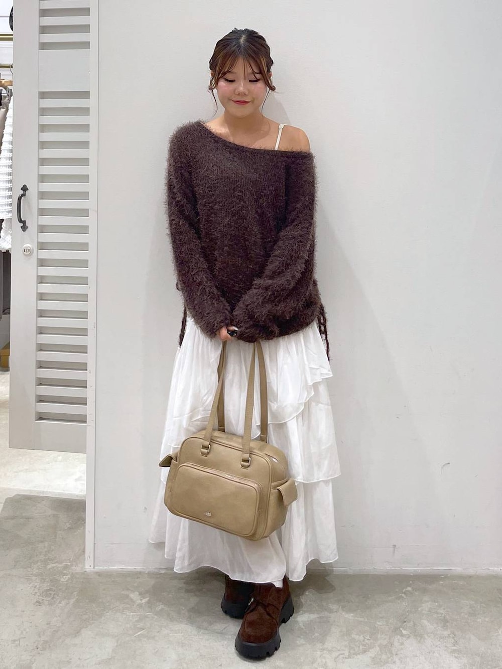 ブラウン系のドレスシューズ、ホワイト系のスカート、ブラウン系のニット/セーターを着用したレディースの秋コーディネートの1枚目の写真