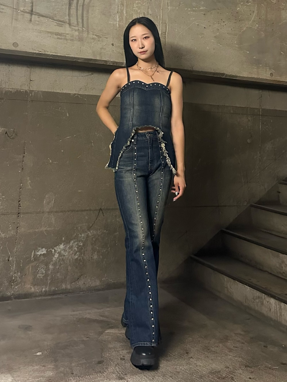 ブルー系のキャミソール、ブルー系のデニムパンツ、ブラック系のブーツを着用したレディースの夏コーディネートの1枚目の写真