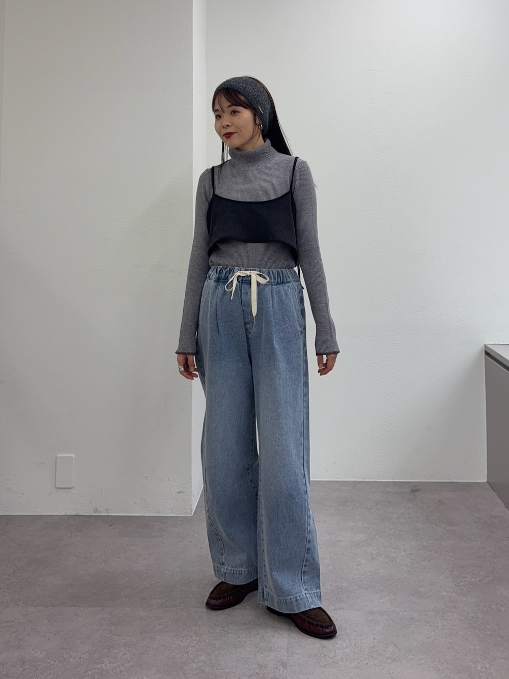 ブルー系のデニムパンツ、レッド系のローファー、グレー系のワンピースを着用したレディースの冬コーディネートの1枚目の写真