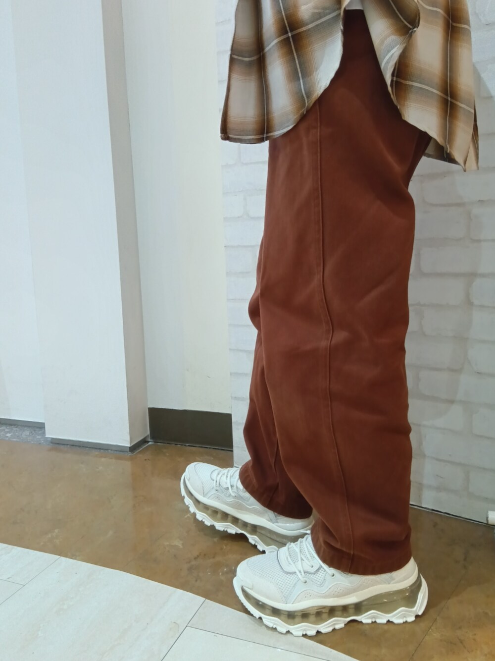 ホワイト系のスニーカーを着用したレディースの秋コーディネートの1枚目の写真