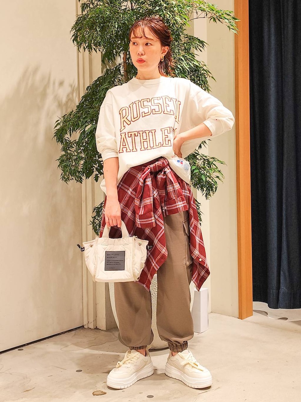 ホワイト系のショルダーバッグ、レッド系のシャツ/ブラウス、ブラウン系のカーゴパンツを着用したレディースの秋コーディネートの1枚目の写真