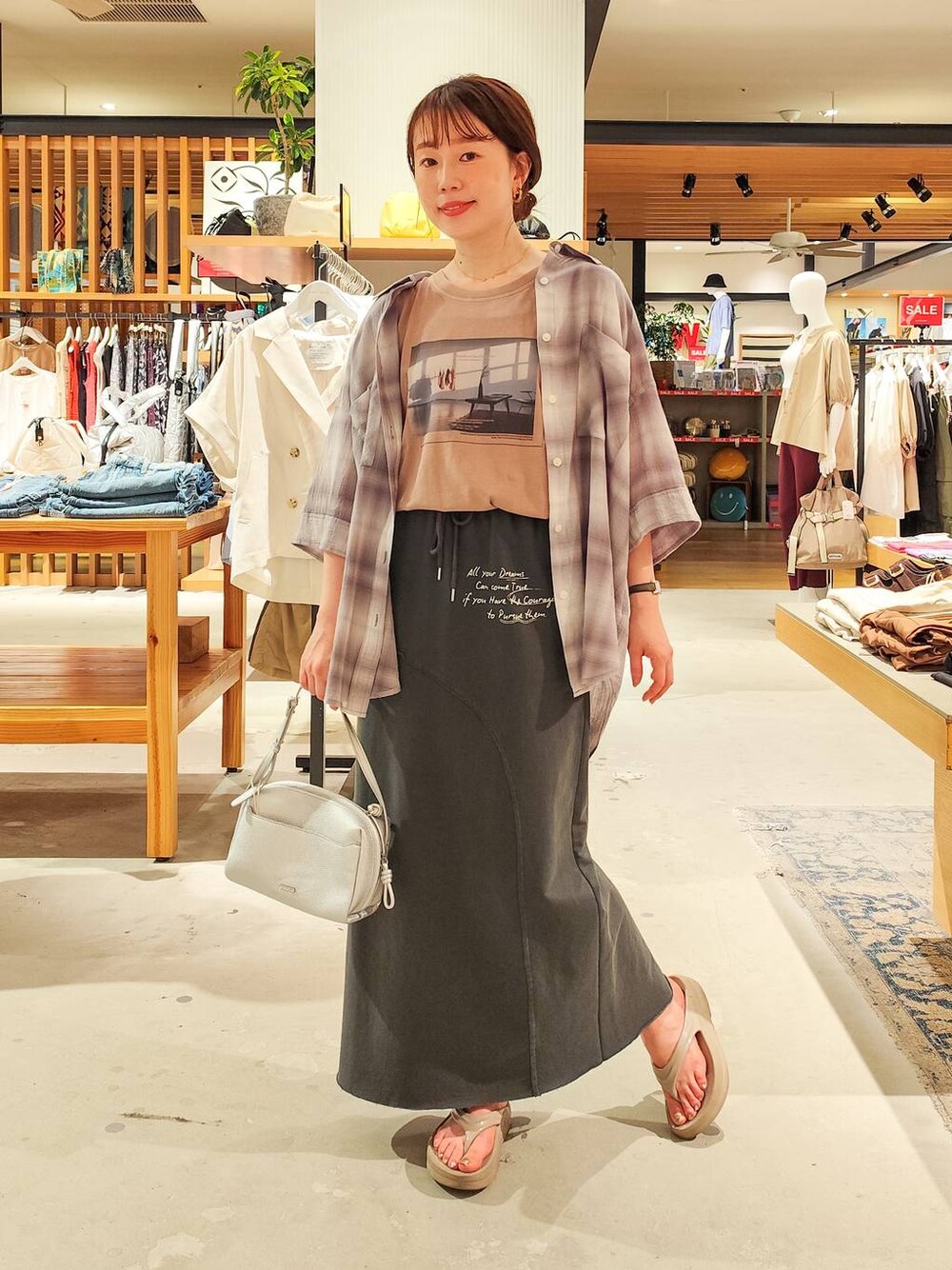 グレー系のシャツ/ブラウス、グレー系のスカート、シルバー系のショルダーバッグを着用したレディースの夏コーディネートの1枚目の写真
