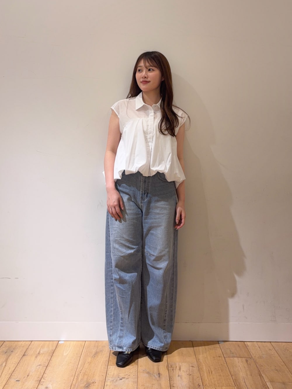 ブルー系のデニムパンツ、ブラック系のパンプス、ブラック系のシャツ/ブラウスを着用したレディースの春コーディネートの1枚目の写真