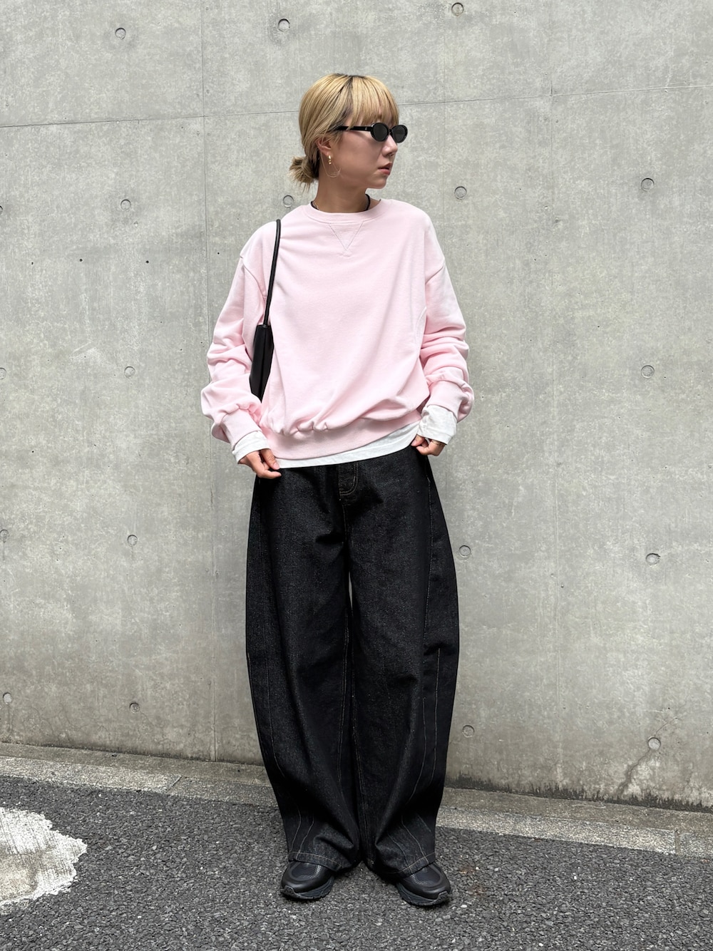 ピンク系のスウェット、ホワイト系のTシャツ/カットソー、ブラック系のデニムパンツを着用したレディースの秋コーディネートの1枚目の写真