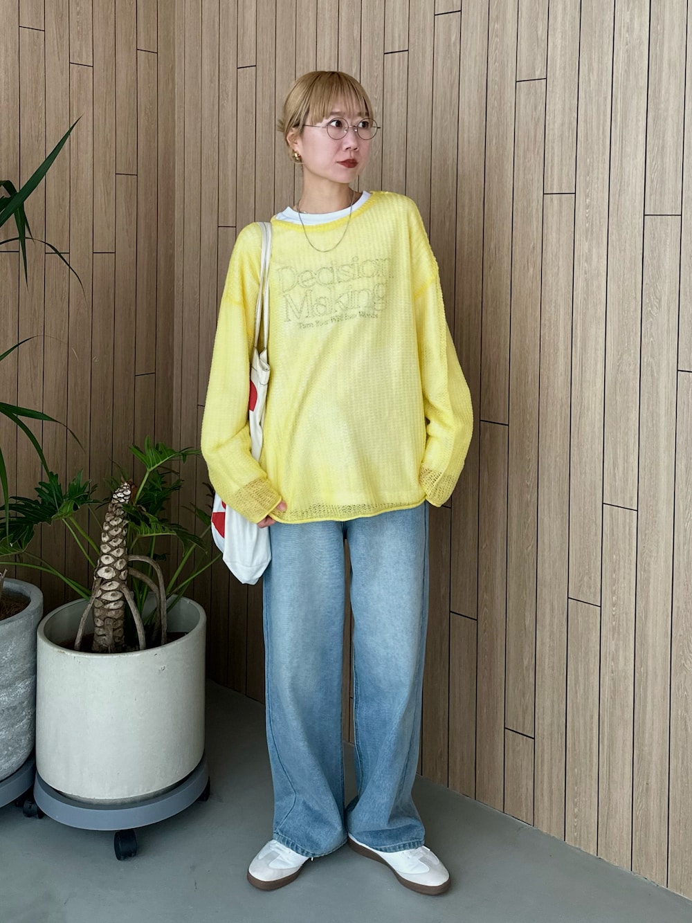 ホワイト系のスウェット、イエロー系のニット/セーター、ブルー系のデニムパンツを着用したレディースの春コーディネートの1枚目の写真