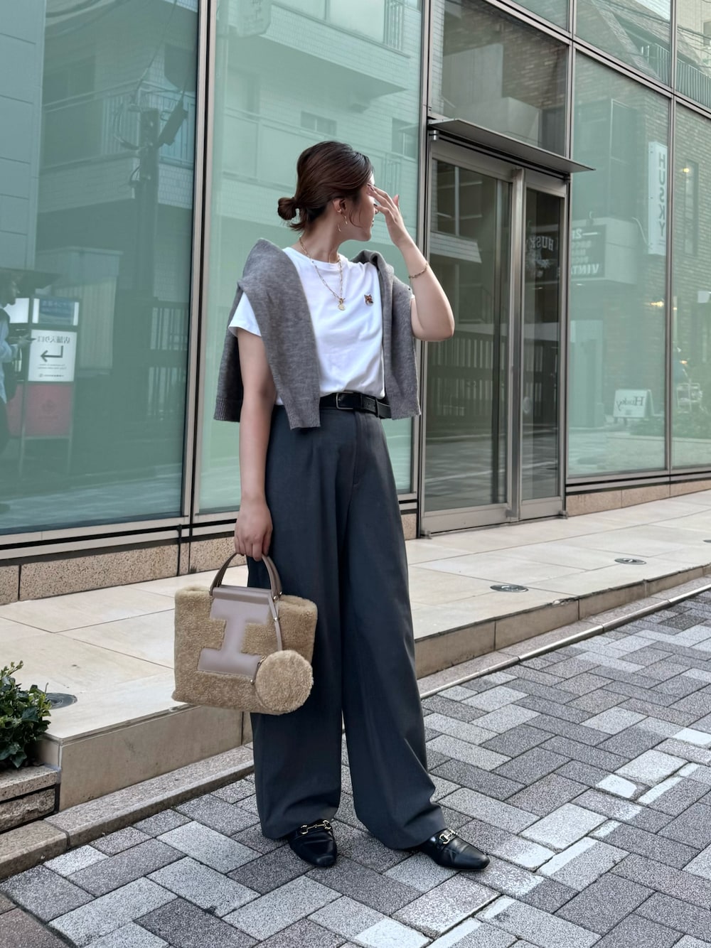 グレー系のスラックス、グレー系のベスト、ホワイト系のTシャツ/カットソーを着用したレディースの秋コーディネートの1枚目の写真