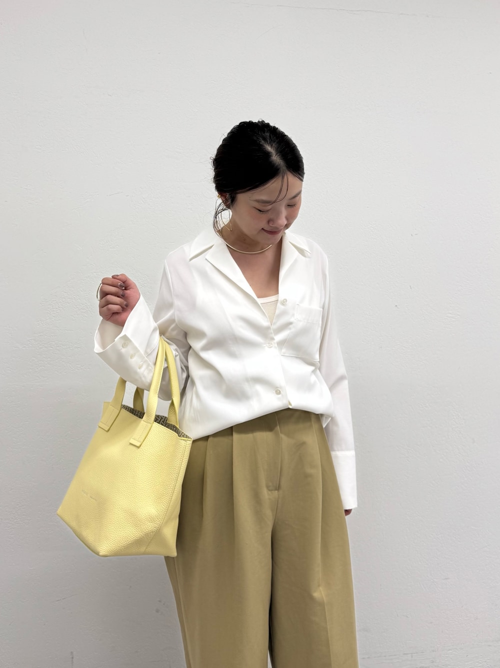 イエロー系のトートバッグを着用したレディースの秋コーディネートの1枚目の写真