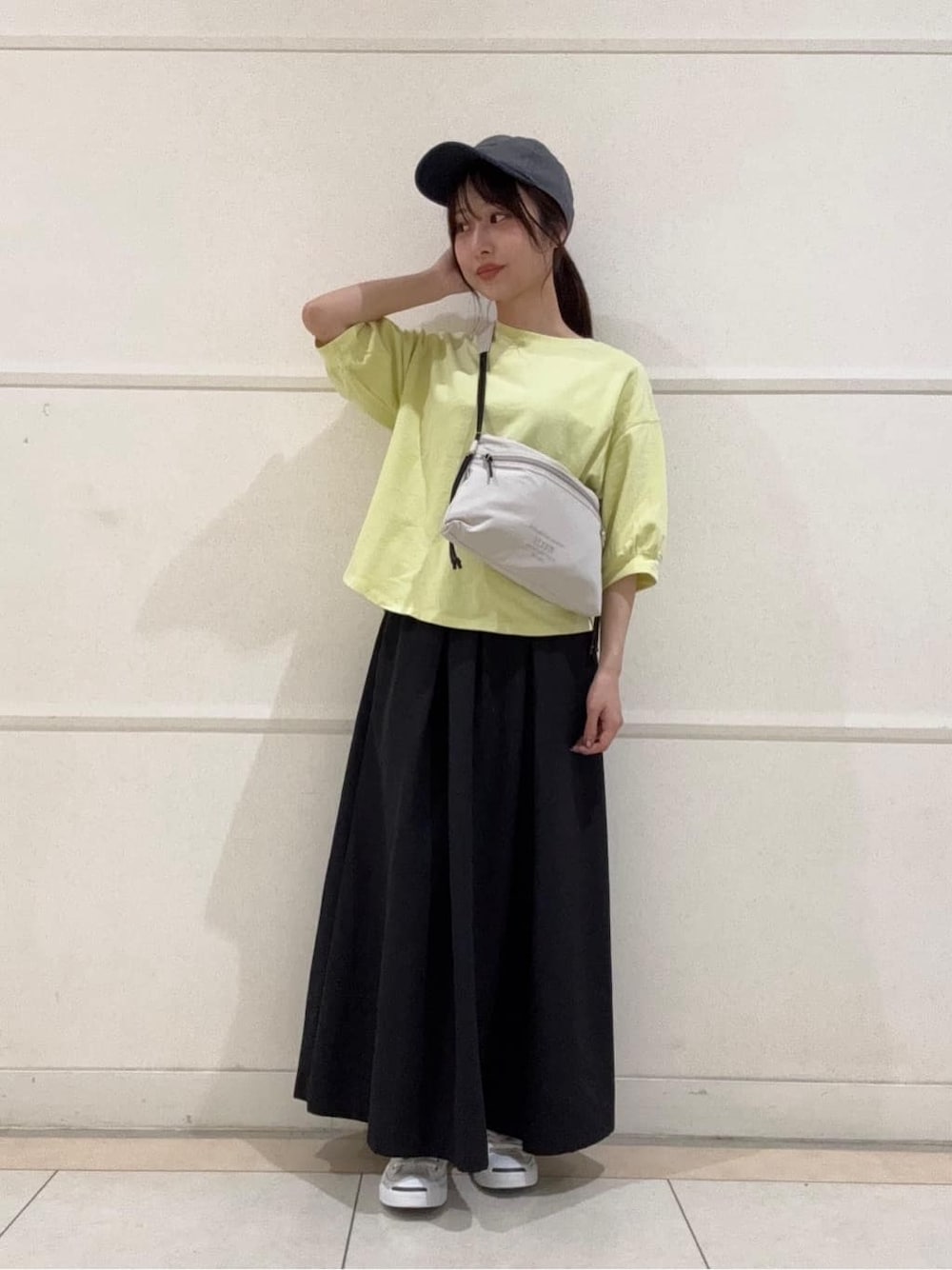 イエロー系のTシャツ/カットソー、ホワイト系のスニーカー、ホワイト系のショルダーバッグを着用したレディースの夏コーディネートの1枚目の写真