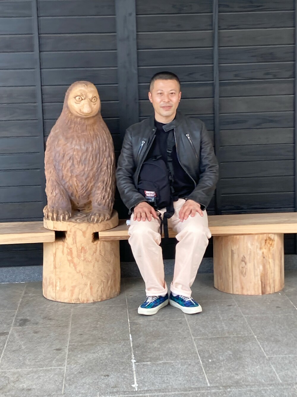 ピンク系のデニムパンツ、グリーン系のスニーカー、ブラック系のライダースジャケットを着用したメンズの春コーディネートの1枚目の写真