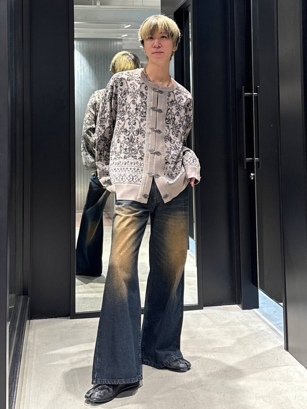 ブルー系のデニムパンツ、ブラック系のTシャツ/カットソー、グレー系のカーディガン/ボレロを着用したメンズの冬コーディネートの1枚目の写真