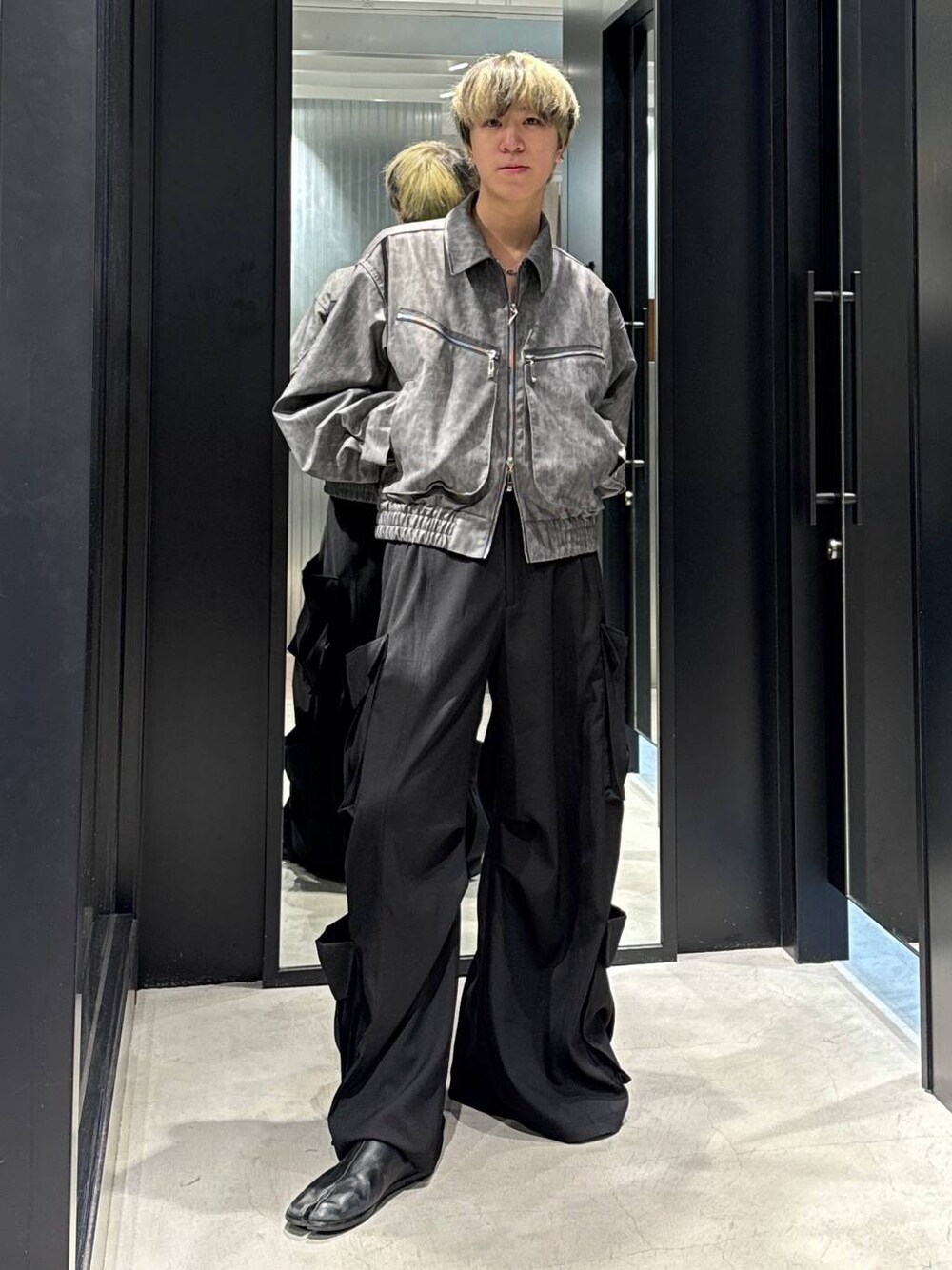 ブラック系のTシャツ/カットソー、グレー系のブルゾン、ブラック系のカーゴパンツを着用したメンズの冬コーディネートの1枚目の写真