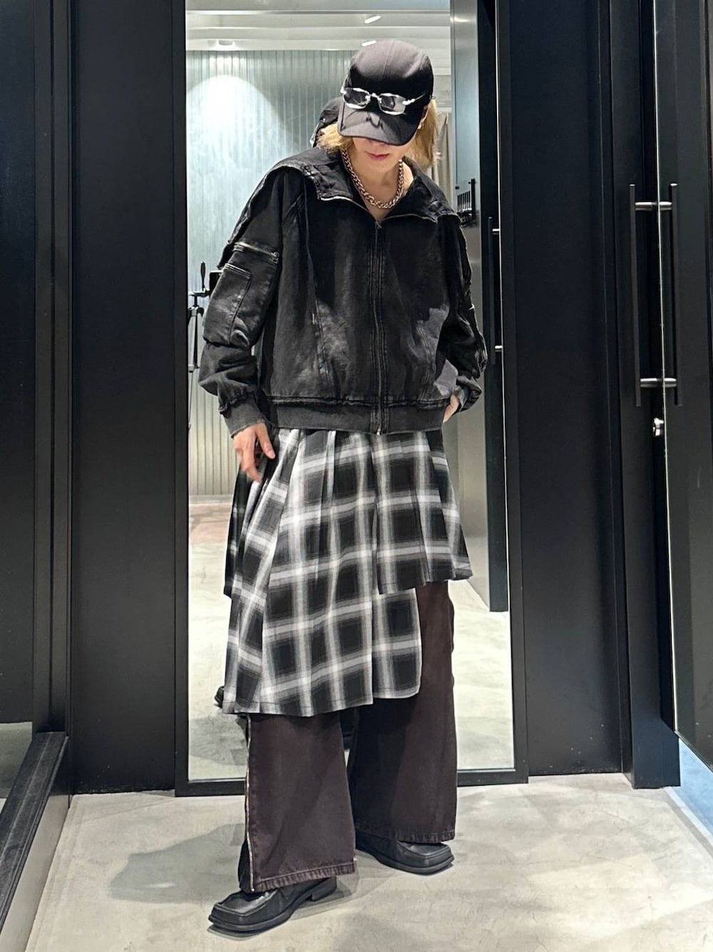 レッド系のデニムパンツ、グレー系のスカート、ブラック系のパーカーを着用したメンズの秋コーディネートの1枚目の写真
