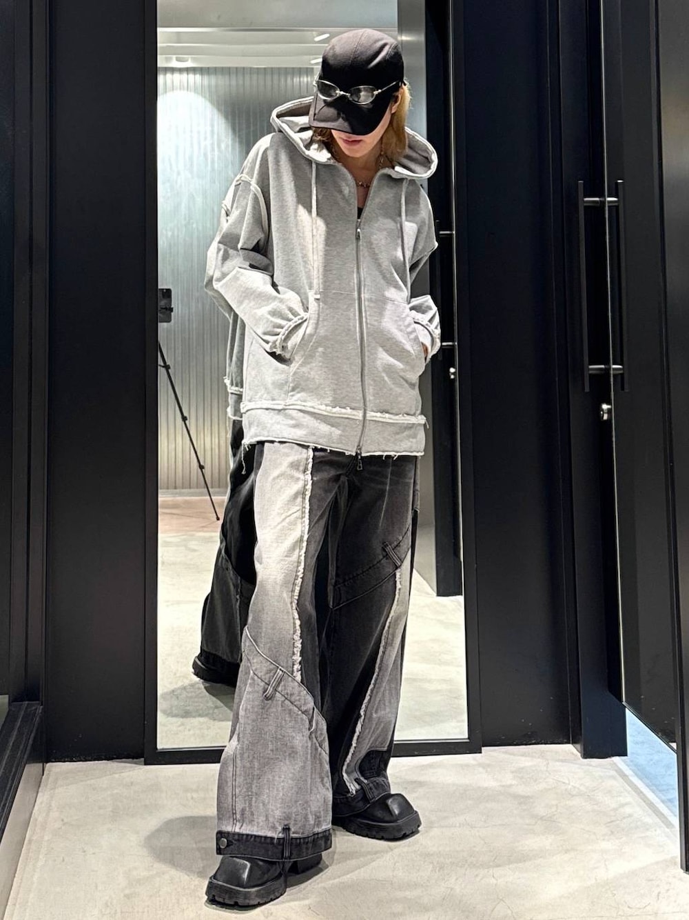 ブラック系のデニムパンツ、グレー系のパーカー、ブラック系のキャップを着用したメンズの秋コーディネートの1枚目の写真