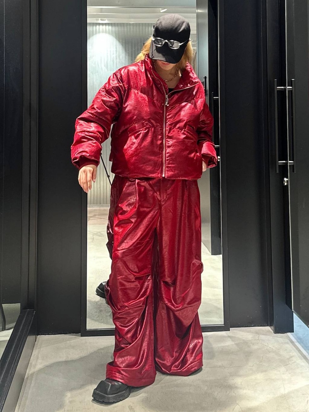 レッド系のブルゾン、レッド系のその他パンツ、ブラック系のキャップを着用したメンズの秋コーディネートの1枚目の写真