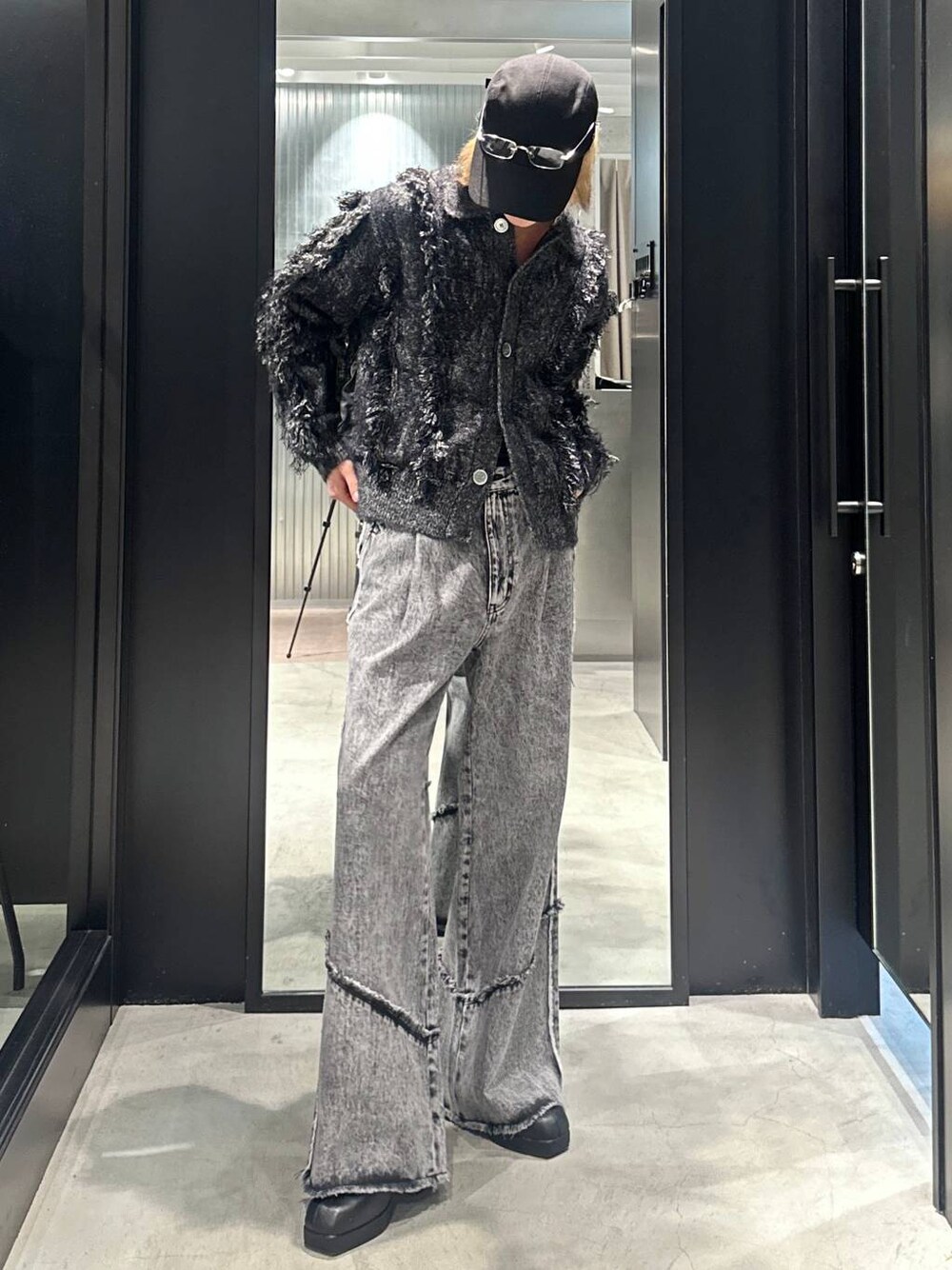 グレー系のデニムパンツ、ブラック系のブーツ、ブラック系のブルゾンを着用したメンズの秋コーディネートの1枚目の写真