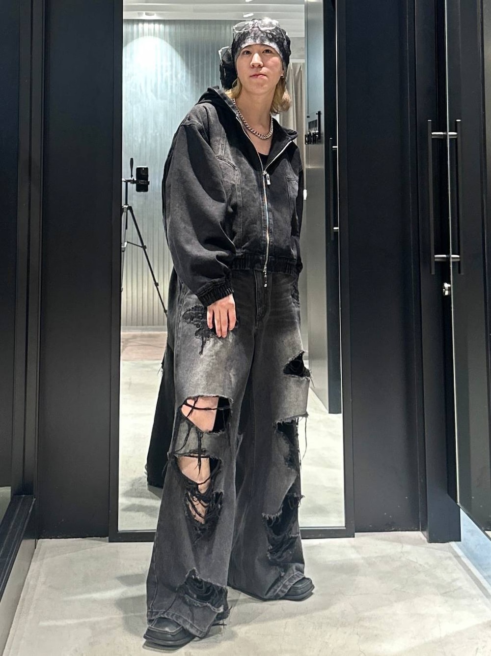 ブラック系のデニムパンツ、ブラック系のブルゾン、シルバー系のネックレスを着用したメンズの秋コーディネートの1枚目の写真