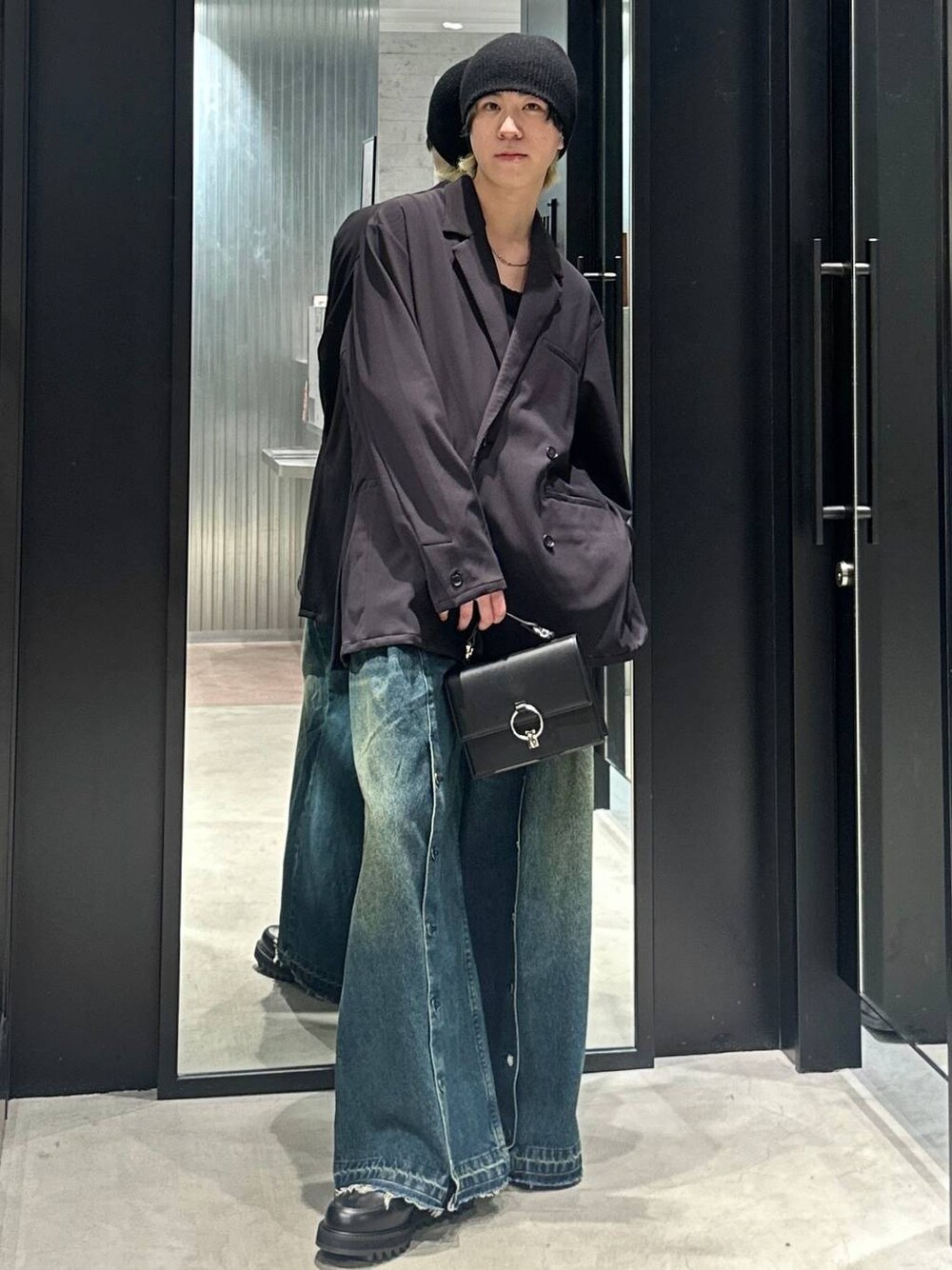 ブラック系のテーラードジャケット、ブルー系のデニムパンツ、ブラック系のショルダーバッグを着用したメンズの春コーディネートの1枚目の写真