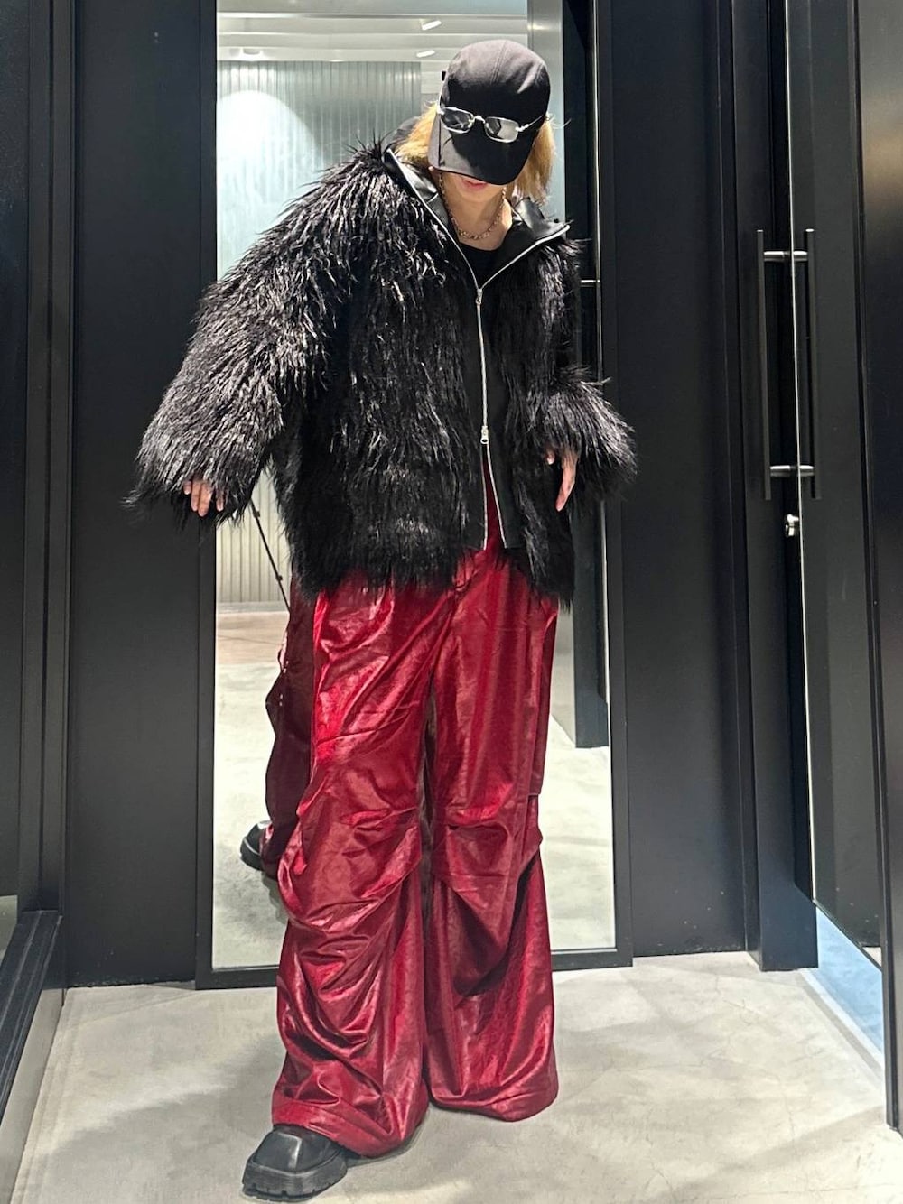 レッド系のその他パンツ、ブラック系のブルゾン、ブラック系のキャップを着用したメンズの秋コーディネートの1枚目の写真