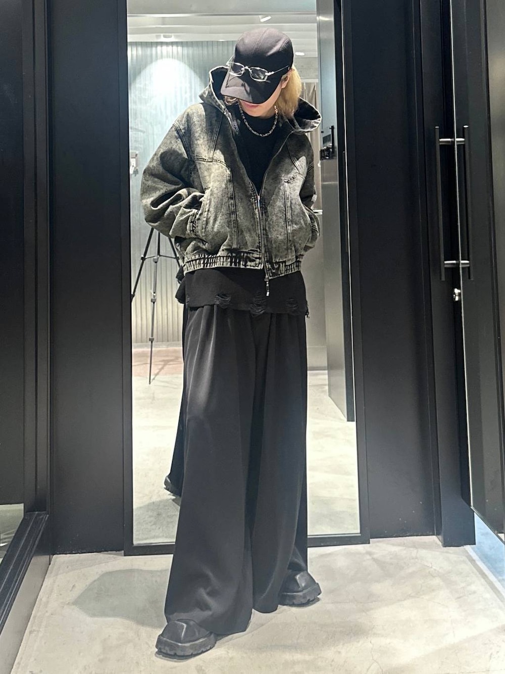 グリーン系のブルゾン、ブラック系のニット/セーター、ブラック系のスラックスを着用したメンズの秋コーディネートの1枚目の写真