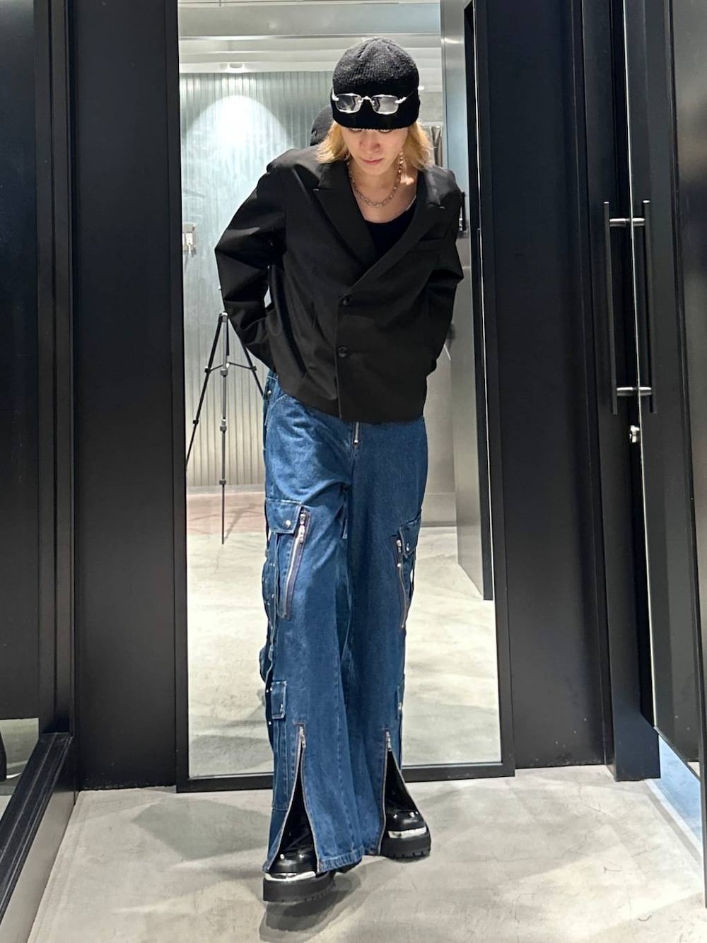 ブラック系のテーラードジャケット、ブラック系のその他シューズ、ブルー系のデニムパンツを着用したメンズの秋コーディネートの1枚目の写真