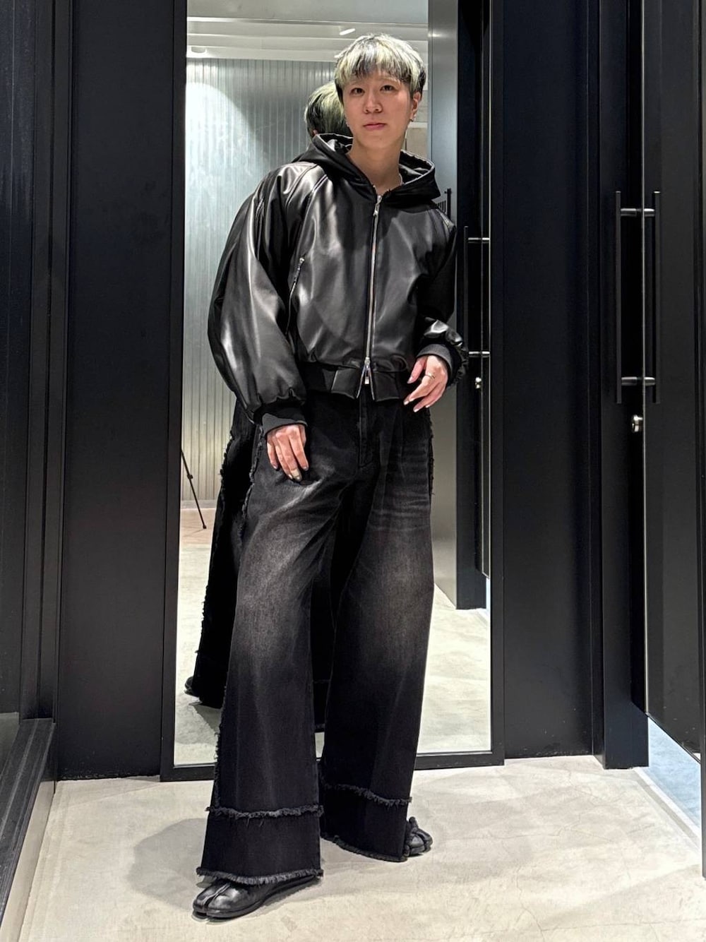 ブラック系のデニムパンツ、ブラック系のブルゾン、シルバー系のネックレスを着用したメンズの冬コーディネートの1枚目の写真