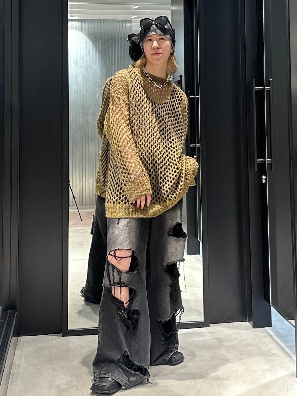 ブラック系のデニムパンツ、イエロー系のニット/セーター、シルバー系のネックレスを着用したメンズの秋コーディネートの1枚目の写真