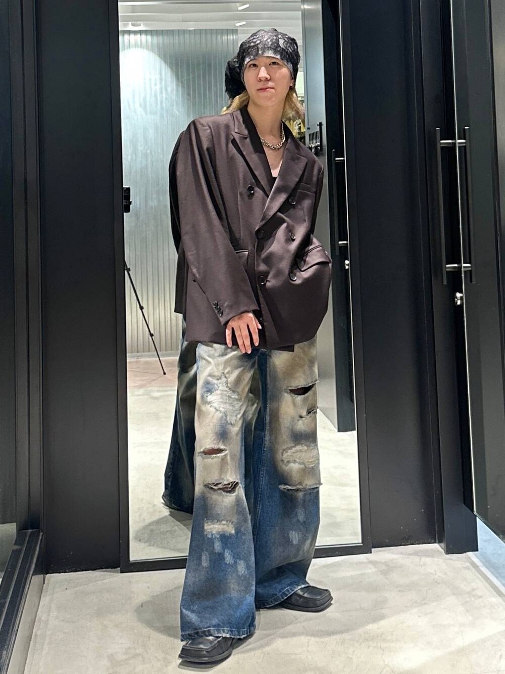 ブラウン系のテーラードジャケット、ブルー系のデニムパンツ、シルバー系のネックレスを着用したメンズの秋コーディネートの1枚目の写真