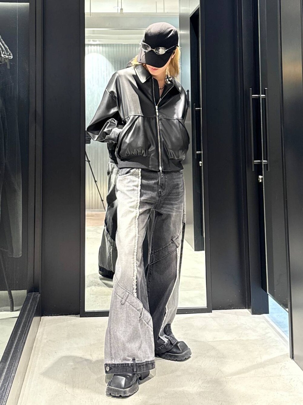ブラック系のデニムパンツ、ブラック系のブルゾン、ブラック系のキャップを着用したメンズの秋コーディネートの1枚目の写真