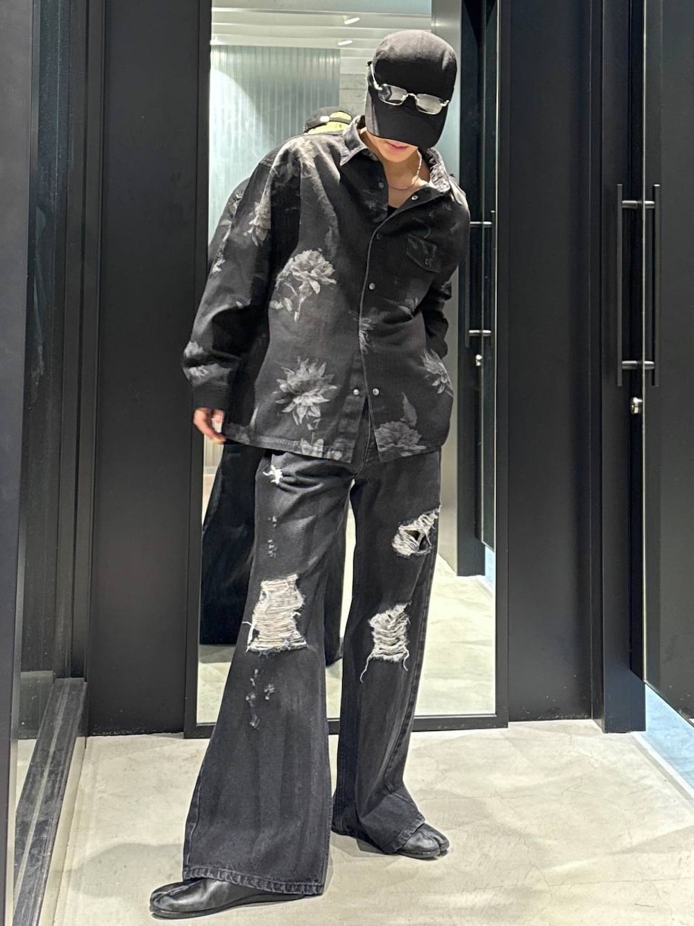 ブラック系のTシャツ/カットソー、ブラック系のデニムパンツ、ブラック系のキャップを着用したメンズの冬コーディネートの1枚目の写真