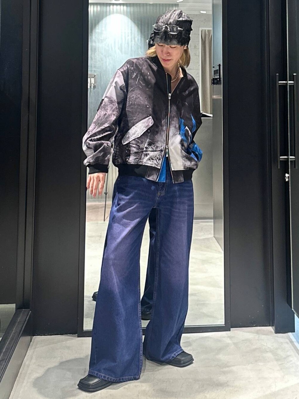 パープル系のデニムパンツ、シルバー系のネックレス、グレー系のニットキャップ/ビーニーを着用したメンズの秋コーディネートの1枚目の写真