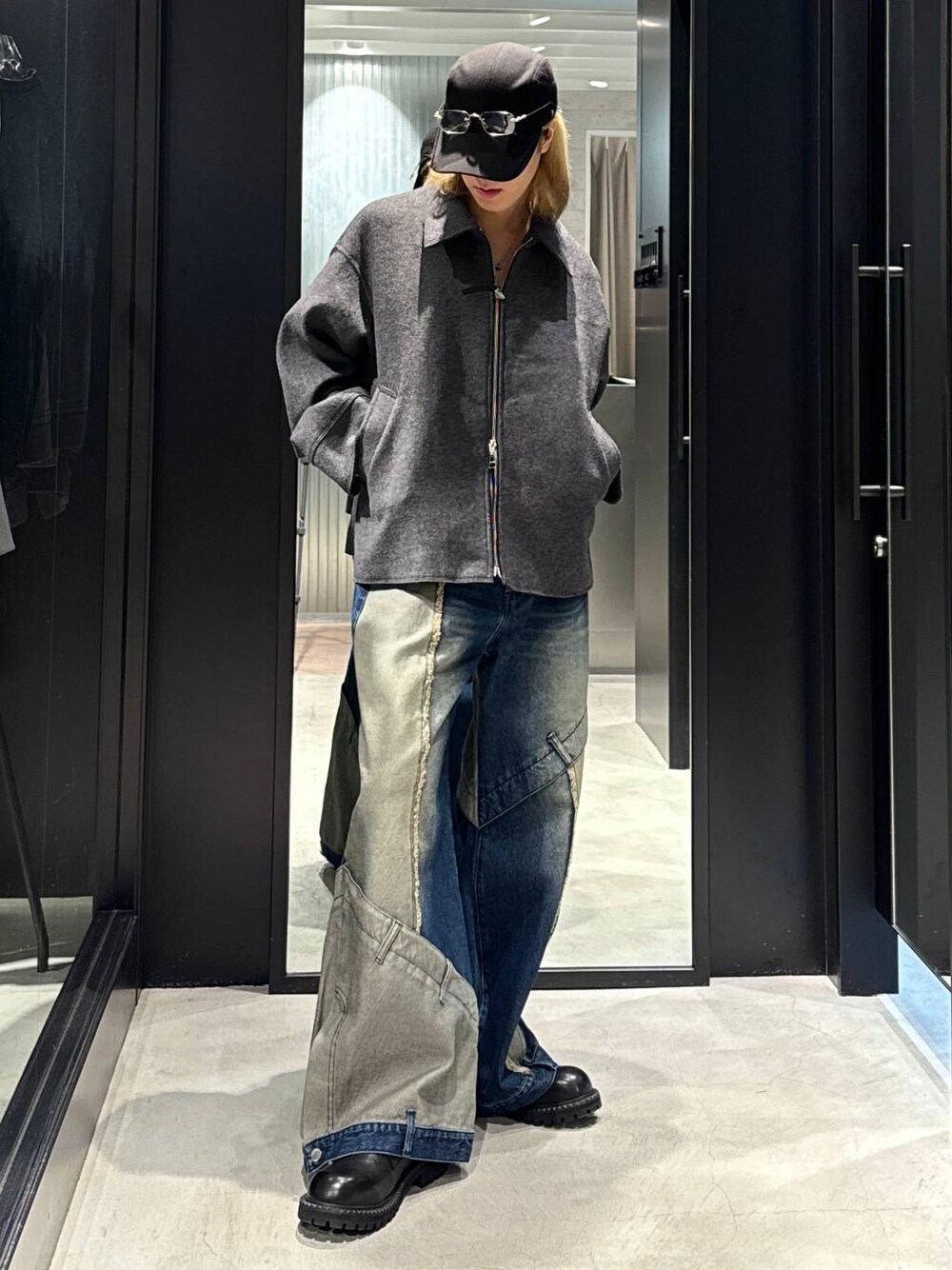 グレー系のブルゾン、ブルー系のデニムパンツ、ブラック系のその他シューズを着用したメンズの秋コーディネートの1枚目の写真