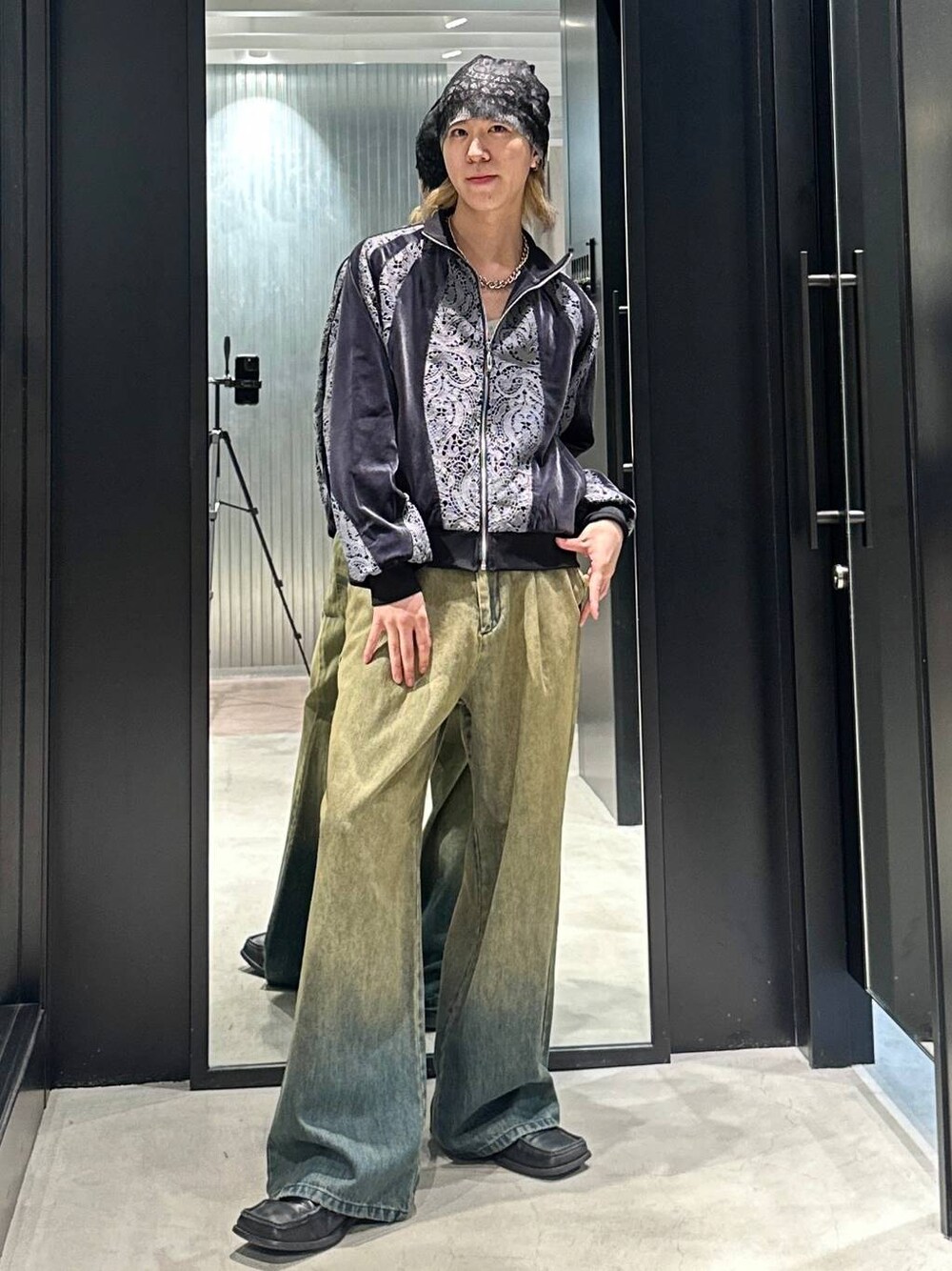 グリーン系のデニムパンツ、グレー系のブルゾン、シルバー系のネックレスを着用したメンズの秋コーディネートの1枚目の写真