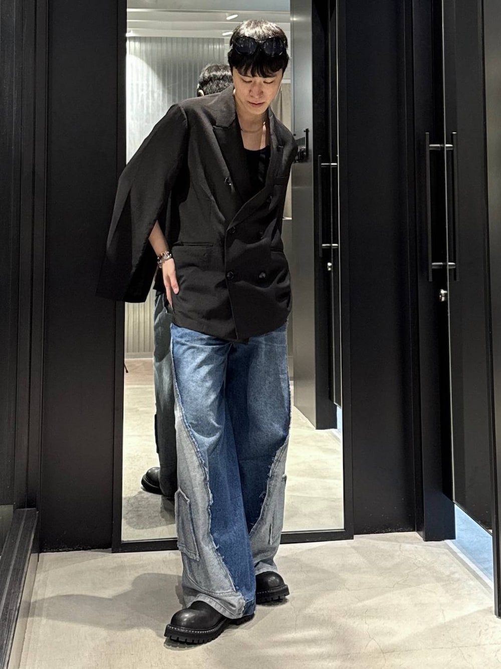 ブラック系のタンクトップ、ブルー系のデニムパンツ、ブラック系のテーラードジャケットを着用したメンズの秋コーディネートの1枚目の写真