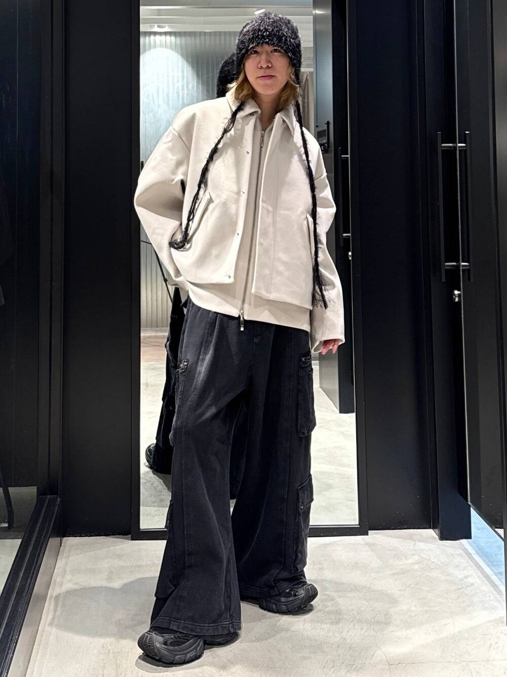 ホワイト系のブルゾン、ブラック系のカーゴパンツ、ブラック系のニットキャップ/ビーニーを着用したメンズの秋コーディネートの1枚目の写真
