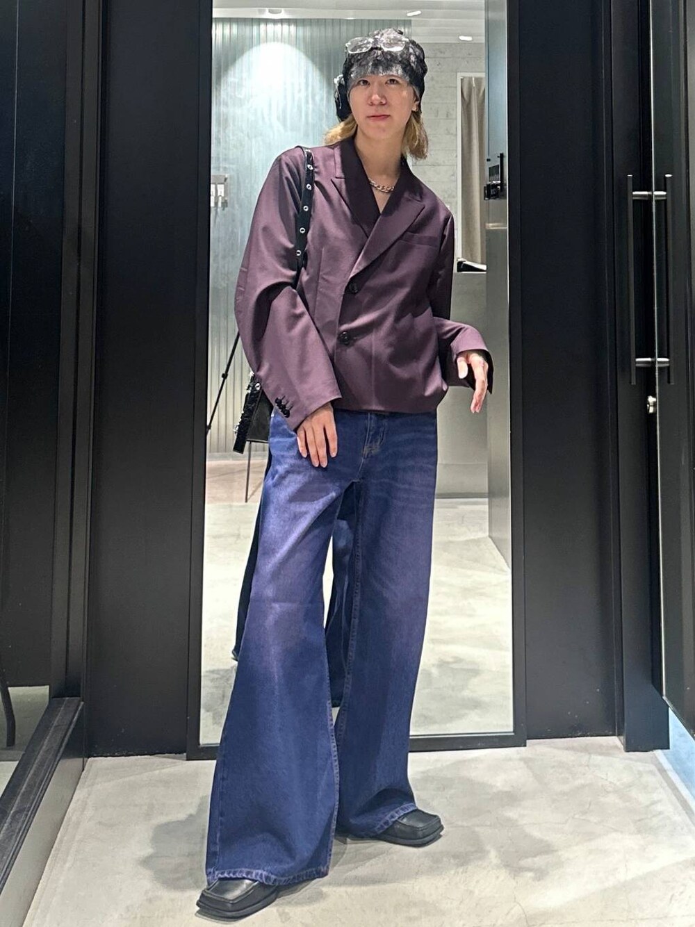パープル系のデニムパンツ、レッド系のテーラードジャケット、ブラック系のショルダーバッグを着用したメンズの秋コーディネートの1枚目の写真