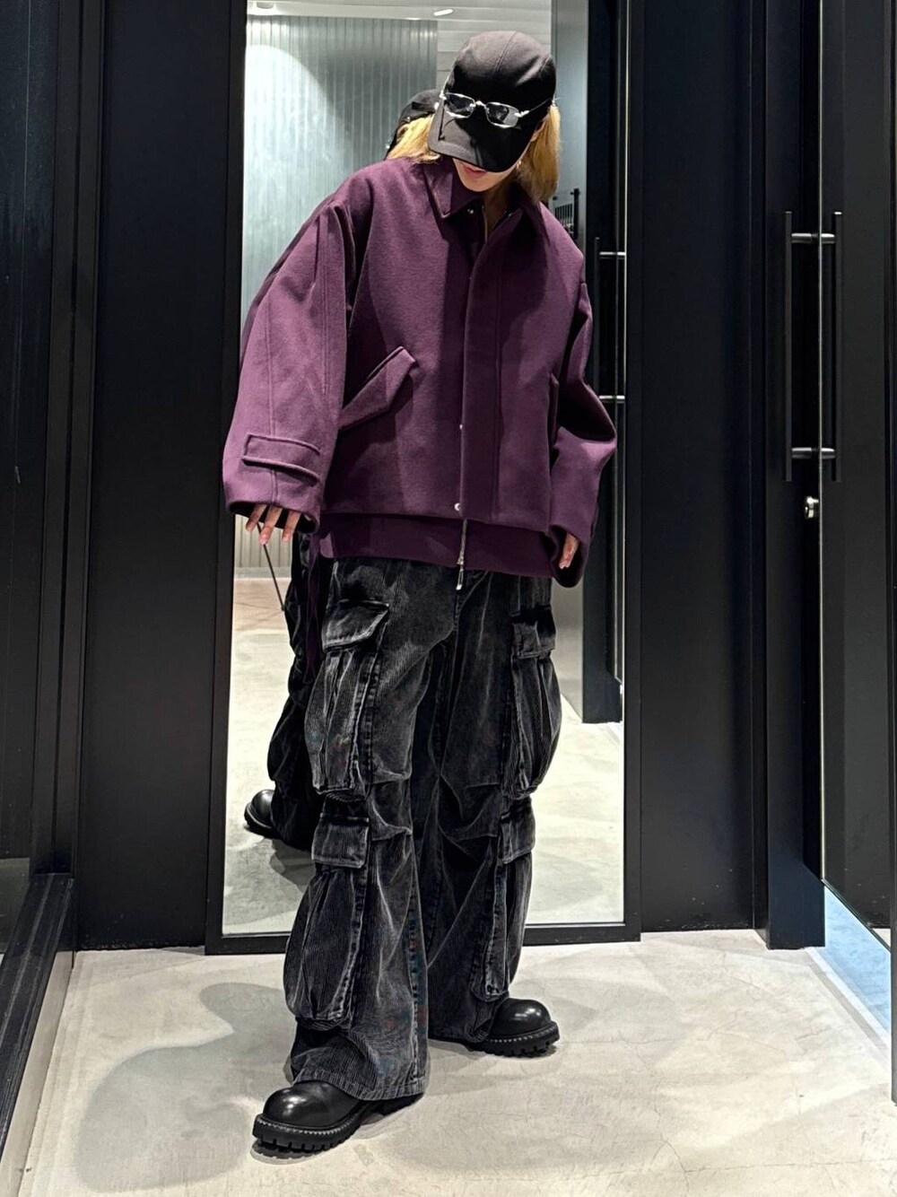 パープル系のブルゾン、ブラック系のその他シューズ、グレー系のカーゴパンツを着用したメンズの秋コーディネートの1枚目の写真