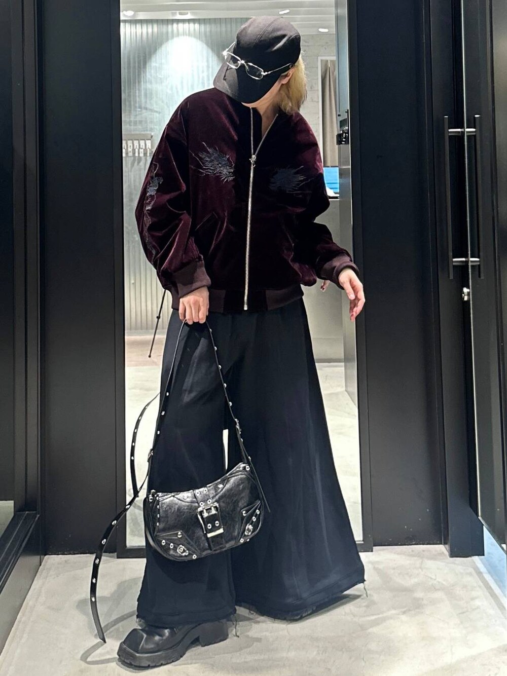 ブラック系のスウェットパンツ、ブラック系のショルダーバッグ、レッド系のブルゾンを着用したメンズの秋コーディネートの1枚目の写真