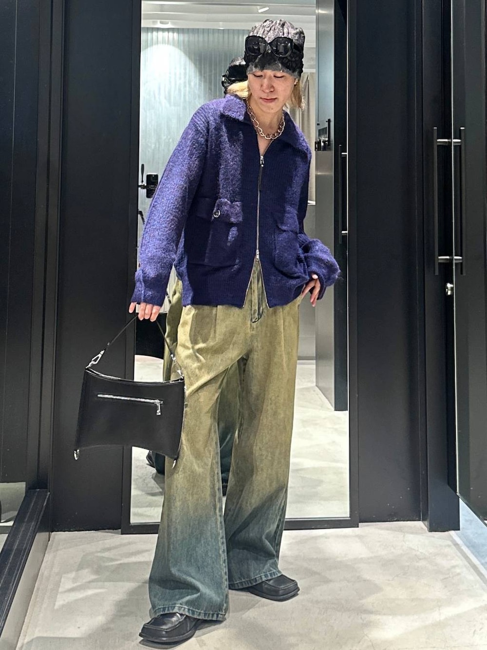 グリーン系のデニムパンツ、ブラック系のショルダーバッグ、ブルー系のニット/セーターを着用したメンズの秋コーディネートの1枚目の写真